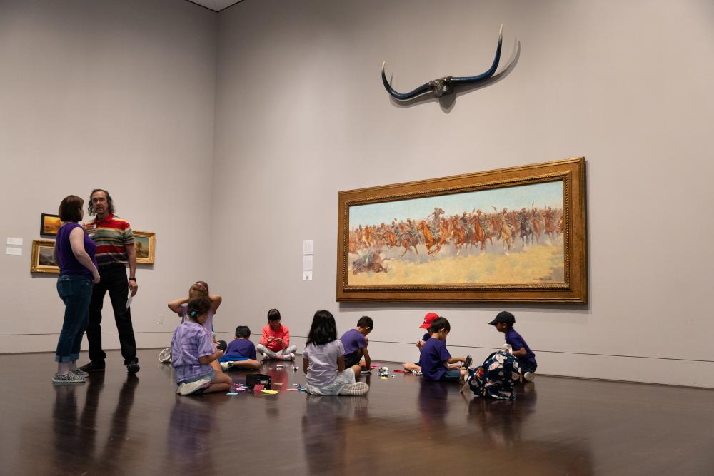 Image of a group of children sitting on the floor in an exhibit at the Blanton Museum.