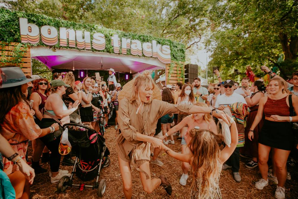 Woman and daughter dancing in a crowd of poeple at ACL Fest.