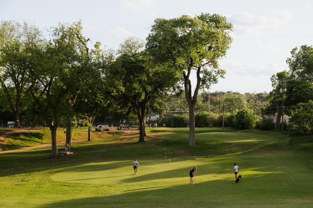 Three men playing golf at Butler Park Pitch and Putt.