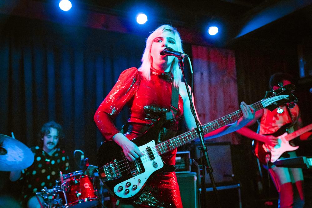 Lead singer and band lit up by red and blue lights on stage at Barracuda during Hot Luck Fest.