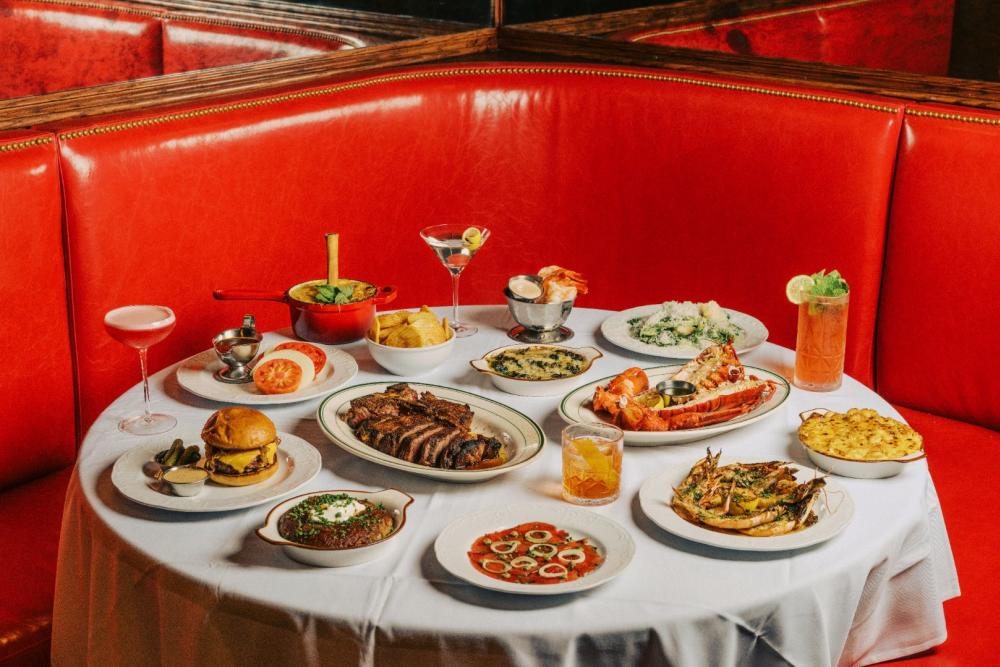 A red booth and table filled with plates of different dishes at VanHorn's.