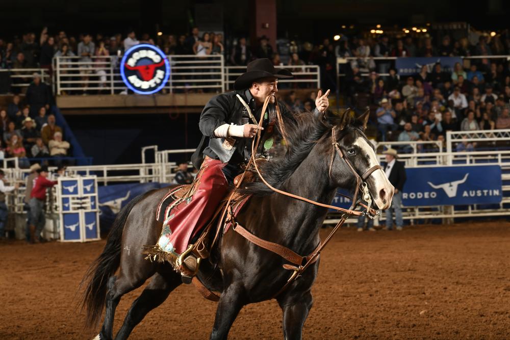Man on horseback rides around area during Rodeo Austin