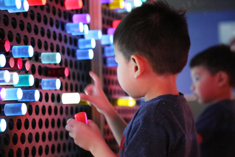 Child playing with light exhibit at the Thinkery Museum in Austin Texas