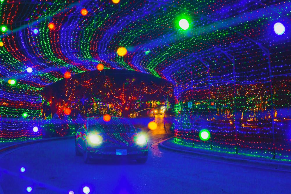 Vehicle driving through multicolor light tunnel at Austin Trail of Lights