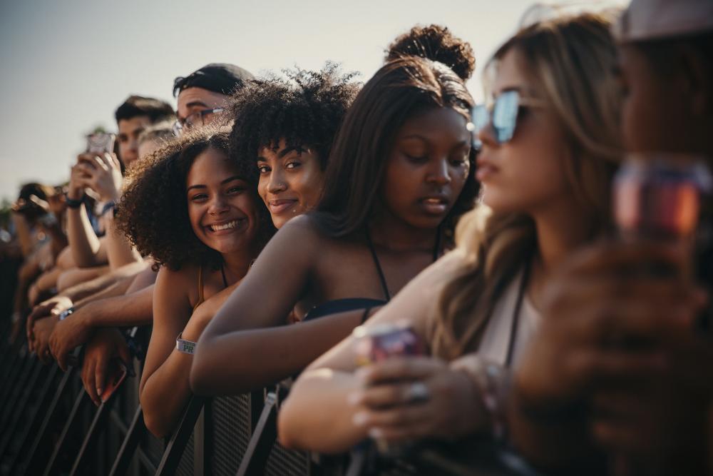 Fans including two women smiling at camera at JMBLYA Festival in Austin Texas