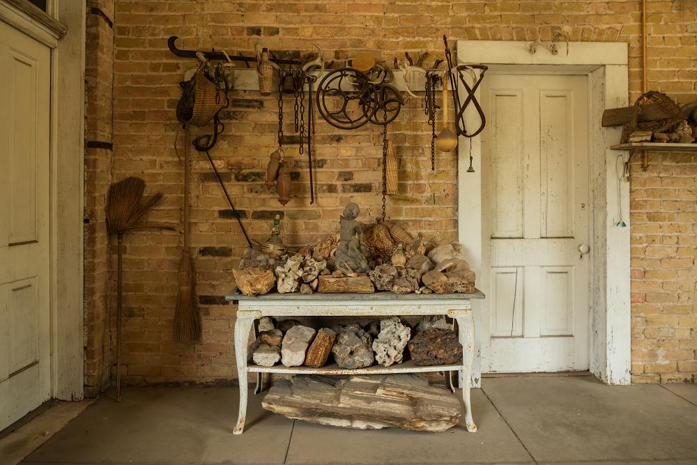 Flower Hill historic mansion Dining Porch with antique tools and rocks on an old table