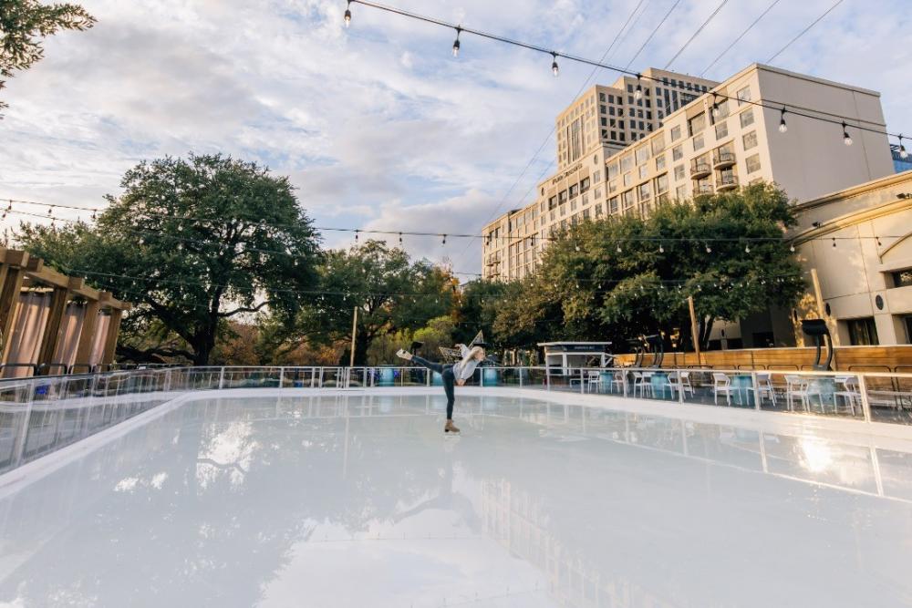 Woman skating on shiny ice outside of the Four Seasons Hotel Austin.