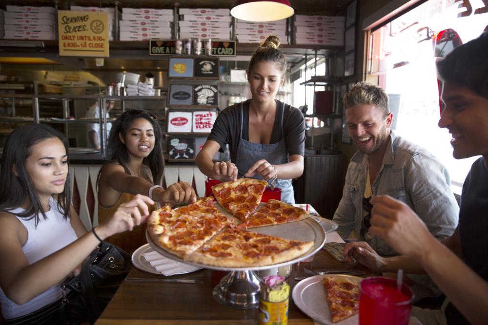 A group enjoying pepperoni pizza at Home Slice