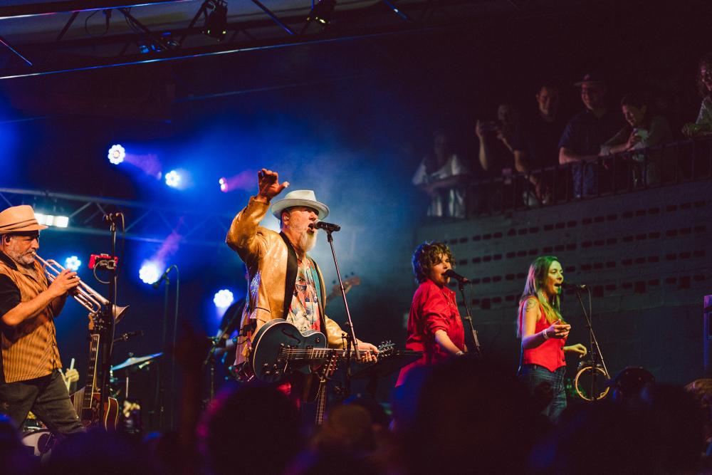 Image of a band onstage at Mohawk with the main man holding his hand up and singing into the microphone.