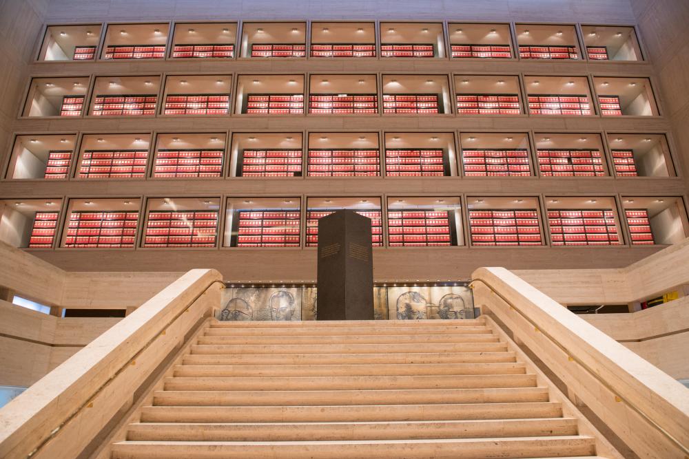 View from bottom of stairs looking up at four floors of glass-enclosed archives.