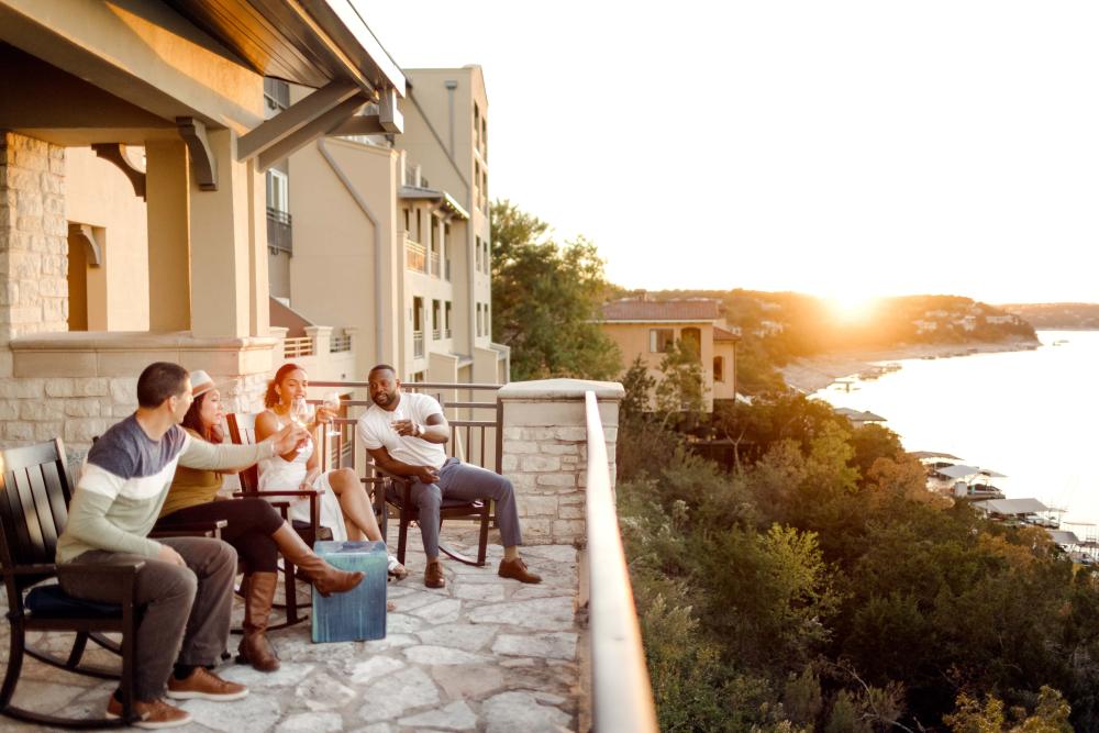 Four people enjoy drinks with a Sunset view from patio at Lakeway Resort and Spa