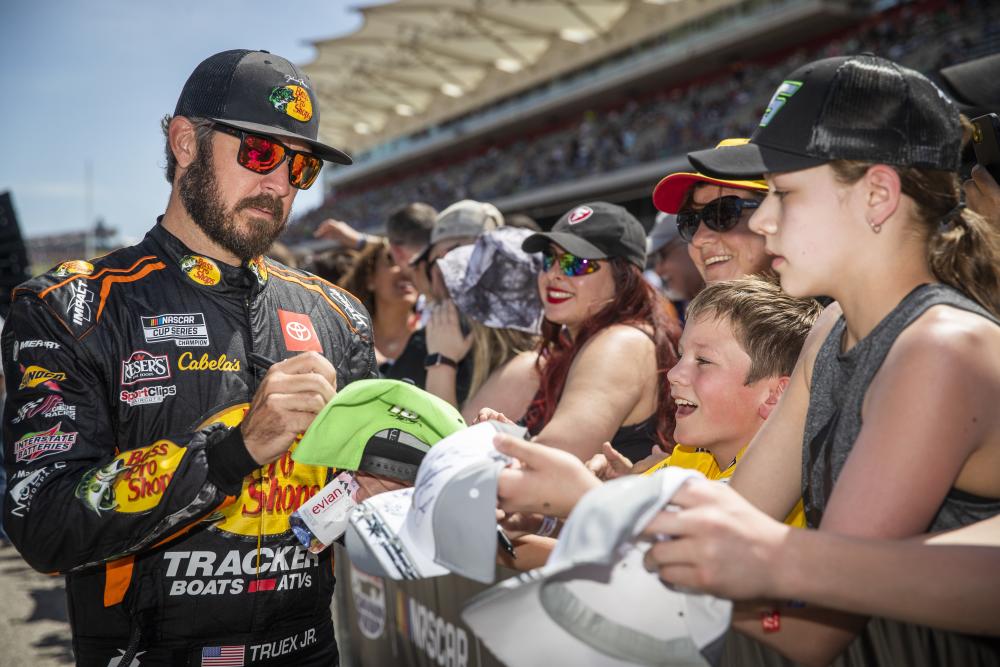 Fans getting memorabilia signed by a NASCAR driver