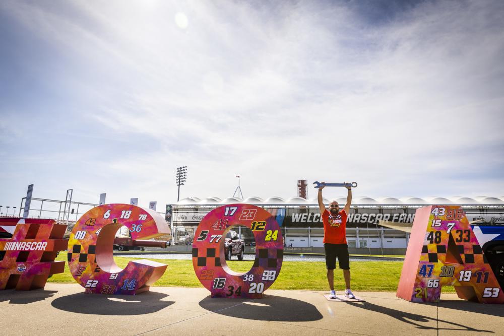Marquee letters spelling out #COTA with a man standing in place of the "T".