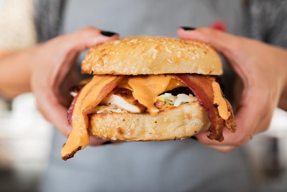 person holding bagel sandwich from Nervous Charlies in austin texas