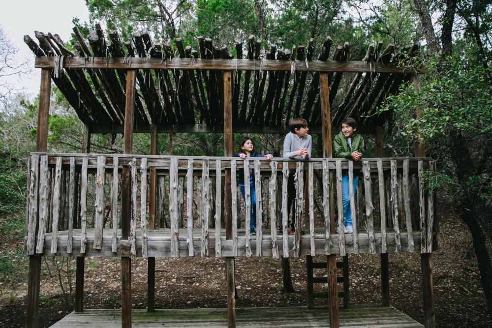 Children playing on wood structure on nature trail at Omni Barton Creek Resort and Spa in Austin Texas