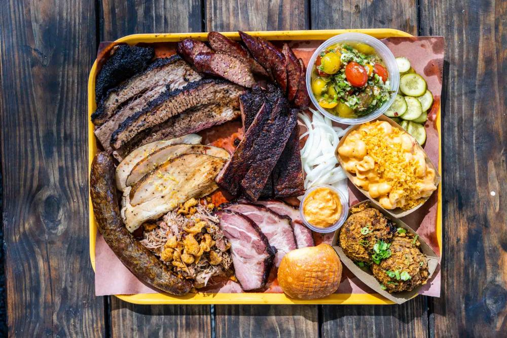 Platter of Cajun-influenced barbecued meats and side dishes.