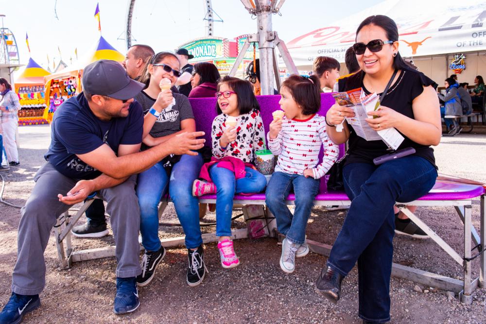 Two adults sit with three children eating ice cream at Rodeo Austin