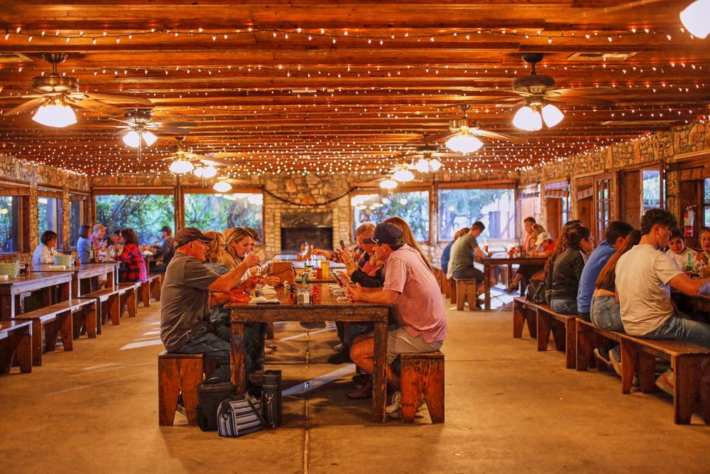 Photo of people sitting at long tables eating barbecue at Salt Lick Barbecue.