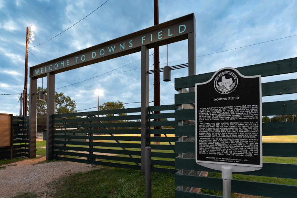 The entrance to Downs Mabson Field with a large gate and historic sign out front.