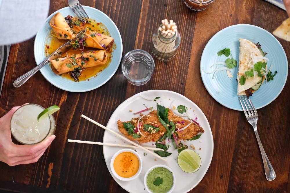 Table top spread of colorful Mexican-Asian fusion dishes at Bar Peached.