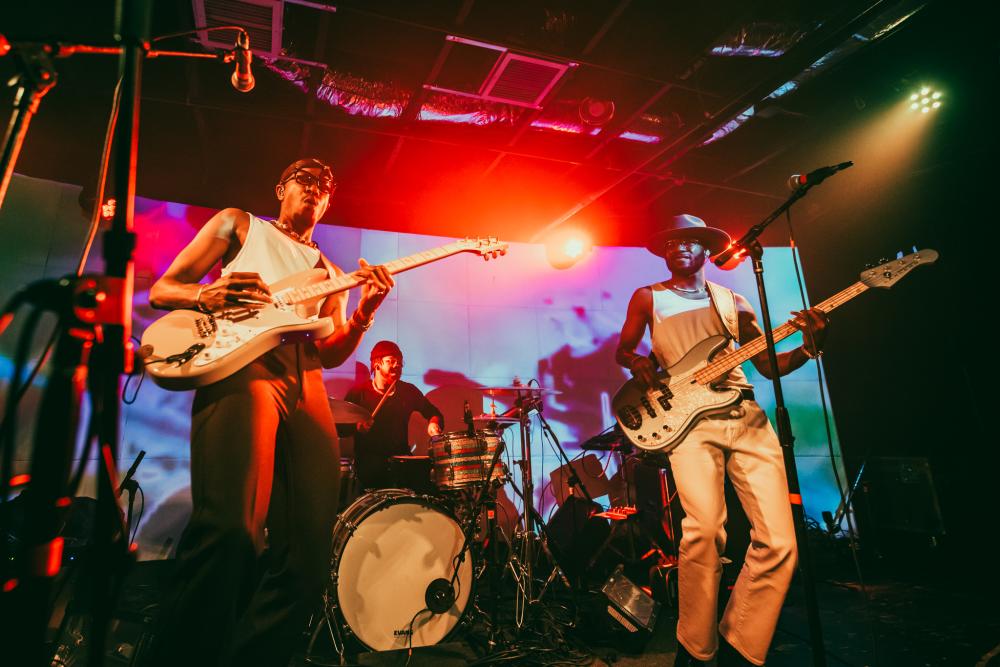 Band on stage with bright, colorful lights shining on them.