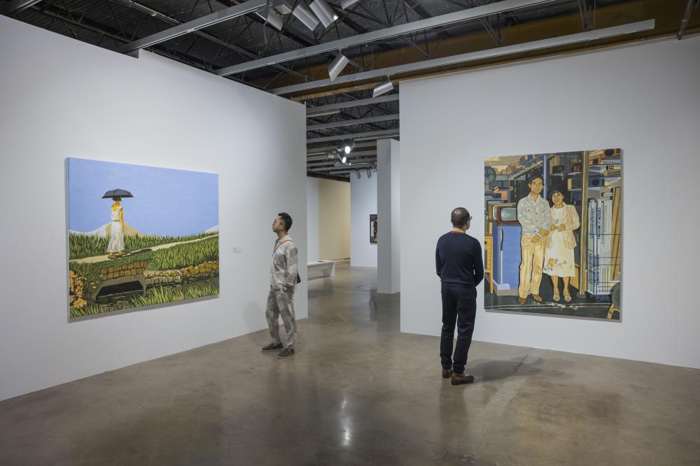 Two men standing inside The Contemporary Jones Center looking at two different artworks on white walls.