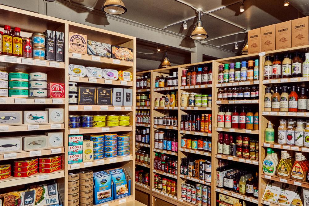Wooden grocery store shelves fully stocked with goods.