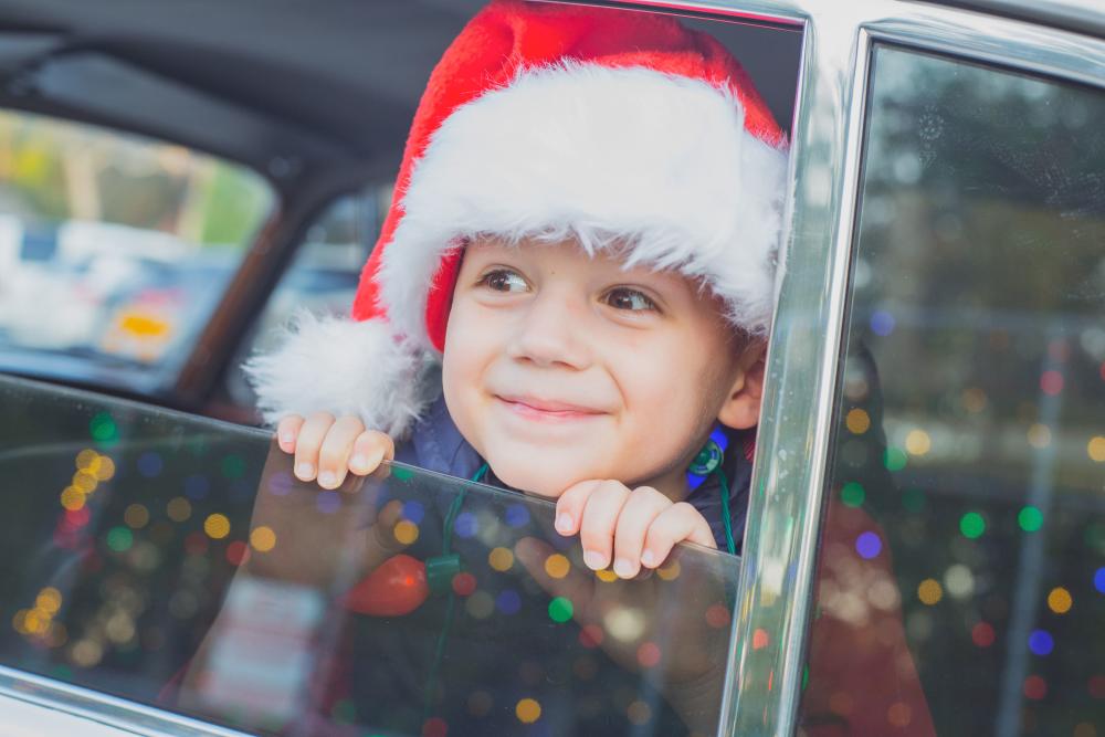 Child peering out of car window at Trail of Lights