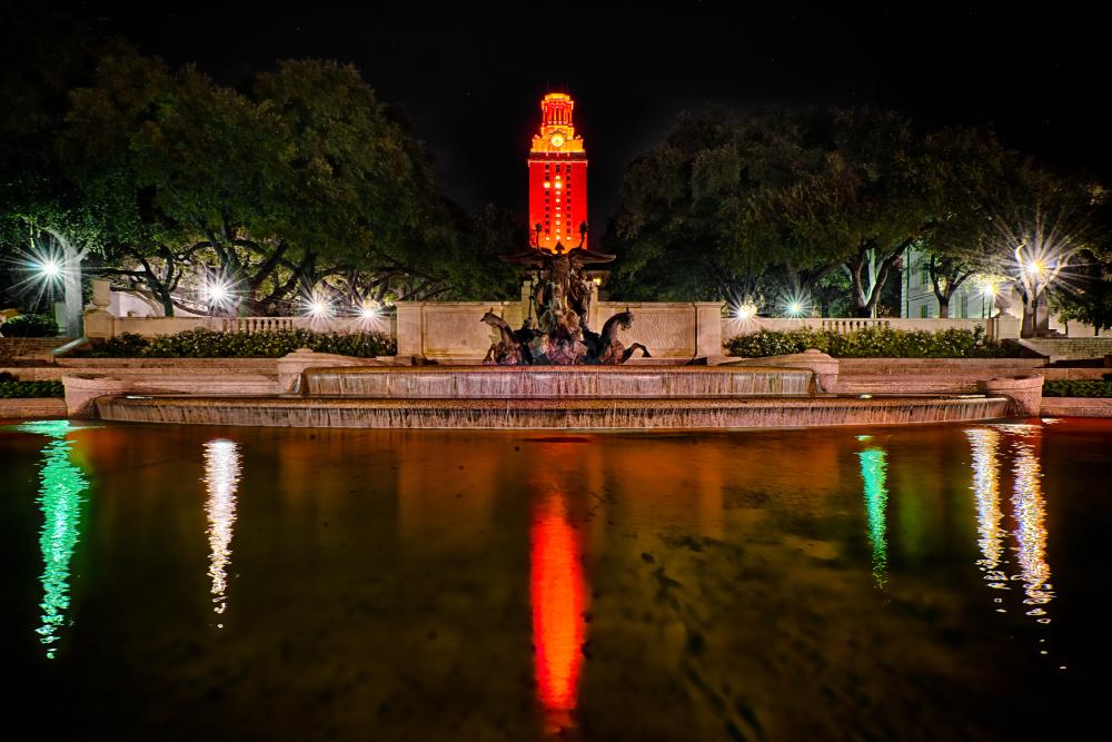 The University of Texas fountain and Tower lit up orange in Austin Texas