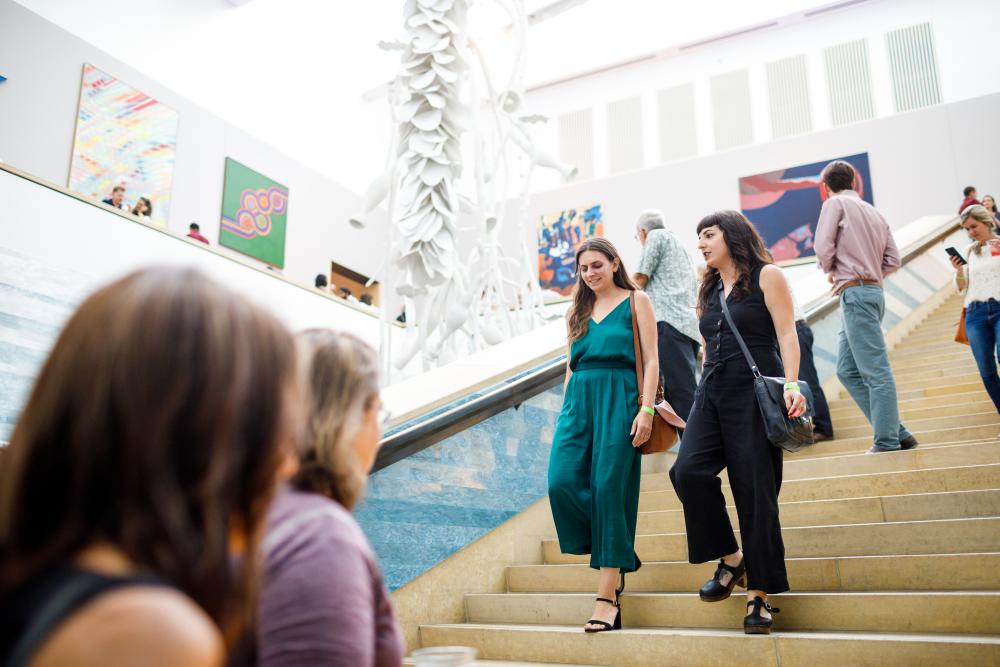 People walking up and down the main staircase at the Blanton Museum of Art.