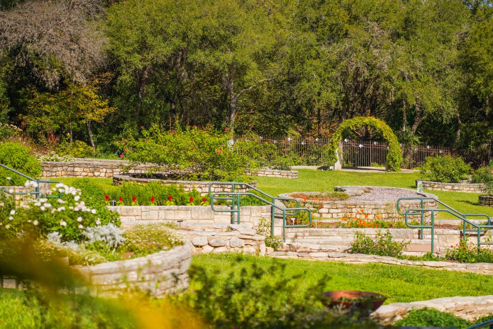 Raised garden beds and stone walkways through the gardens at Zilker Botanical Garden.