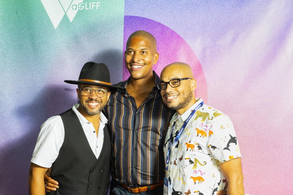 Quincy Le Near, Nathan Hale Williams and Deondray Gossett take a photo together in front of an ombre background at aGLIFF festival