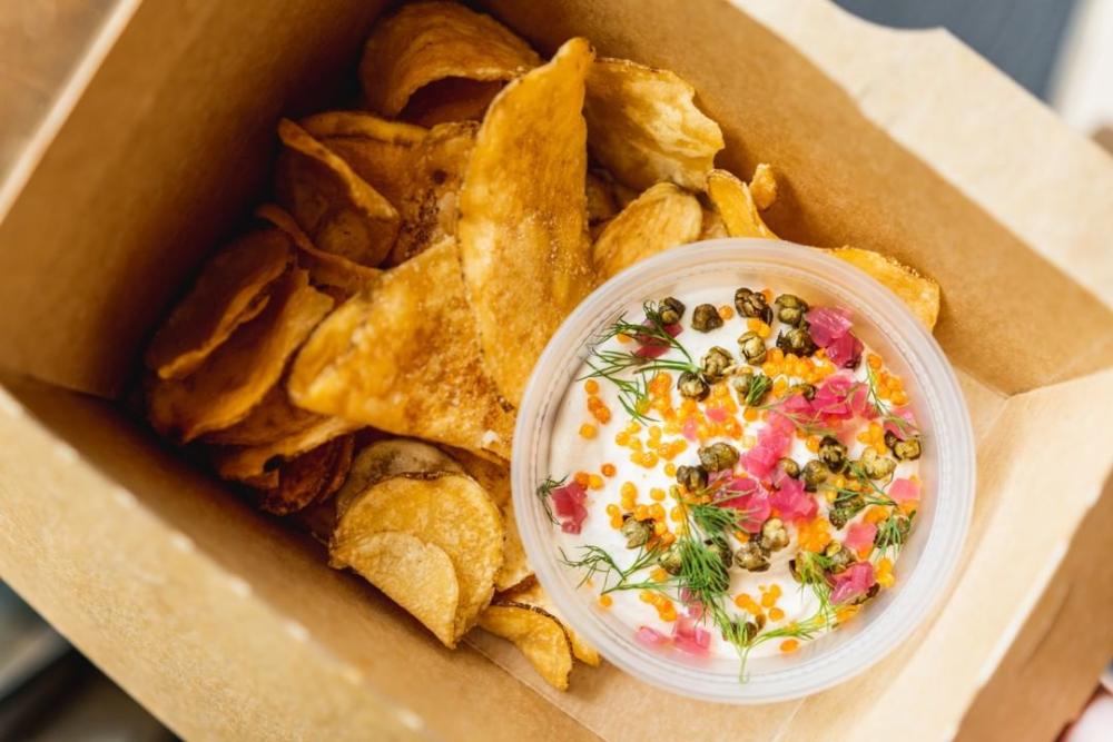 Smoked Salmon Sour Cream Dip and chips in takeout container from Drop Kick in Austin TExas