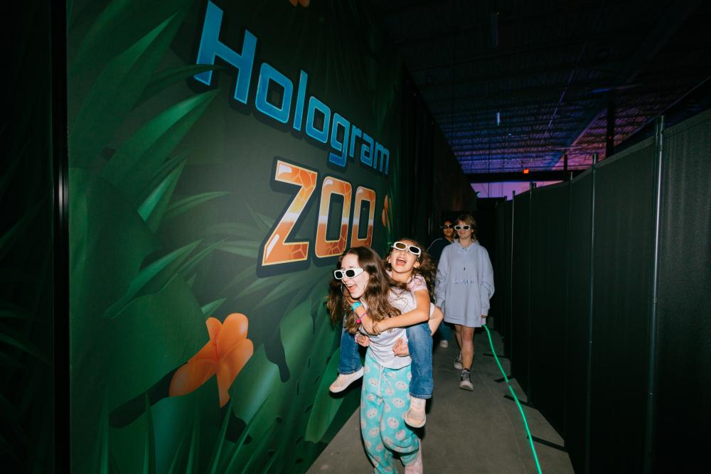 Kids of different ages smiling as they move through the Zoocade.