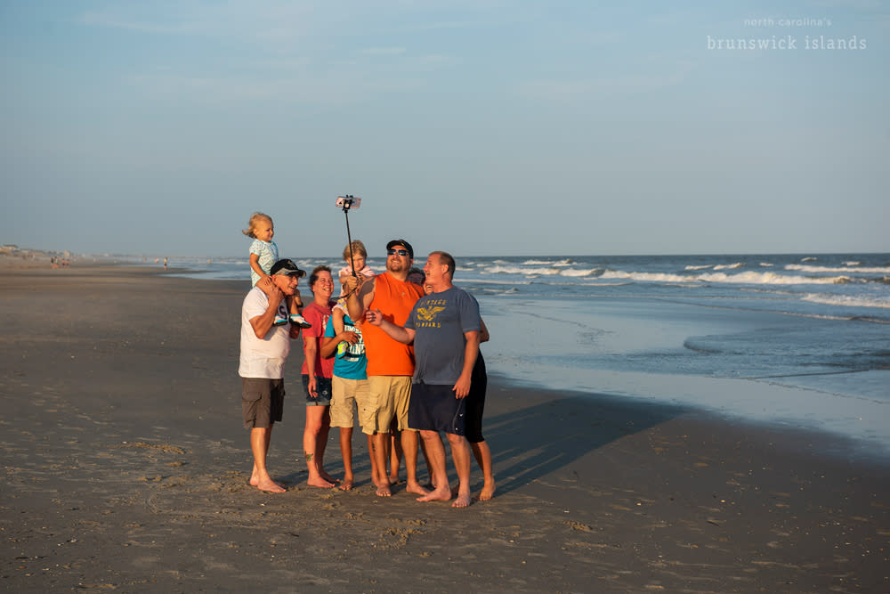 An extended family taking a selfie on the beach