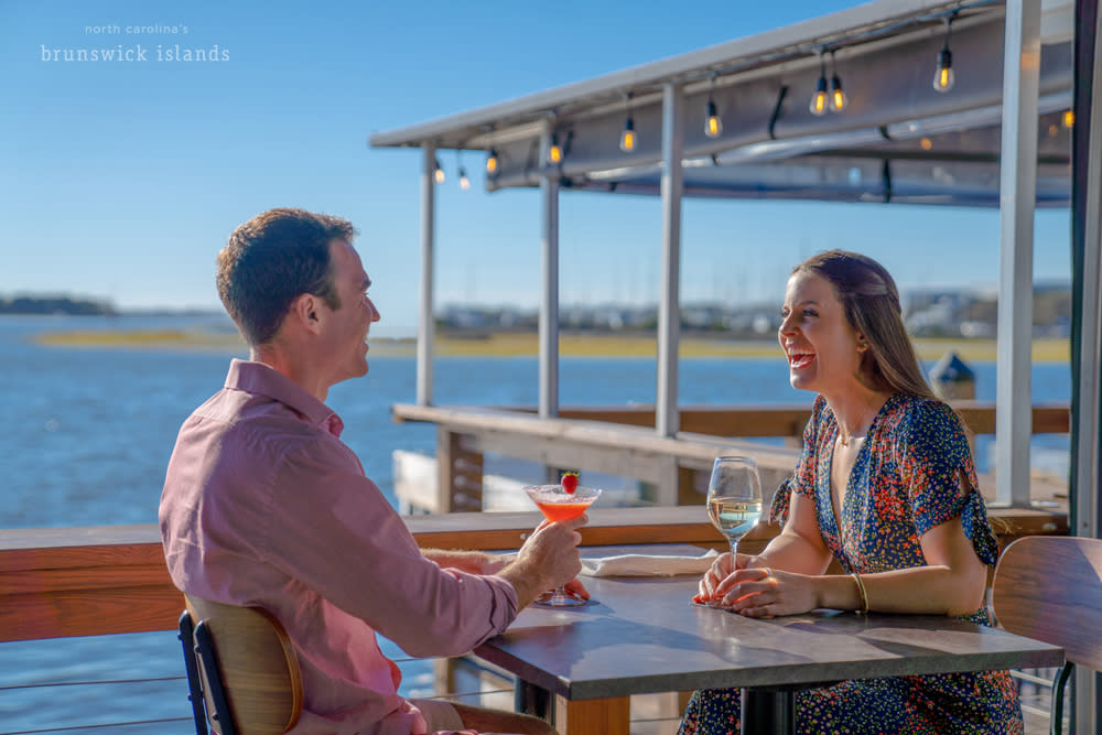 a couple sharing drinks at a waterfront restaurant