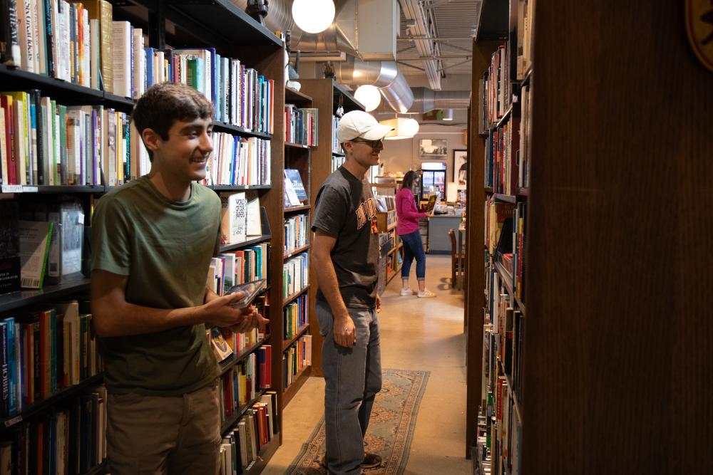 Two White male visitors browse the book shelves at Totem Books.