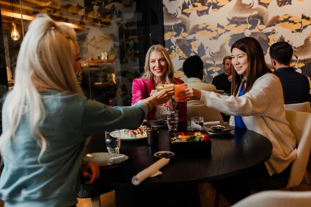 A group of women cheers with cocktails at Japango in Fort Collins