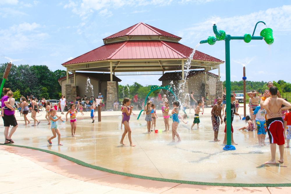 Kids cooling off in a splash pad at Buckner Parl