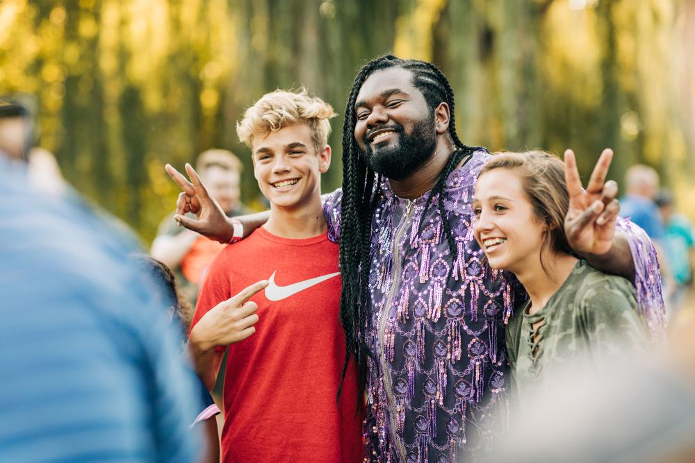 performer Tunde Olaniran poses for a photo with two festivalgoers at middle waves music festival