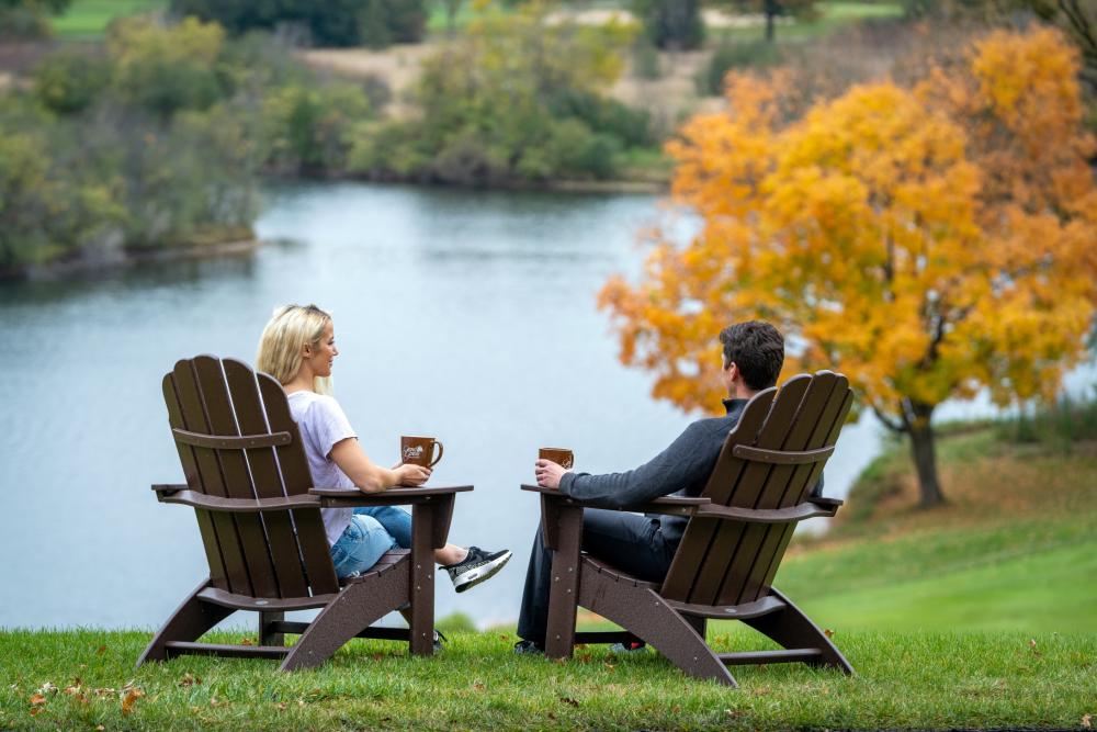 Couple sitting by the water in fall