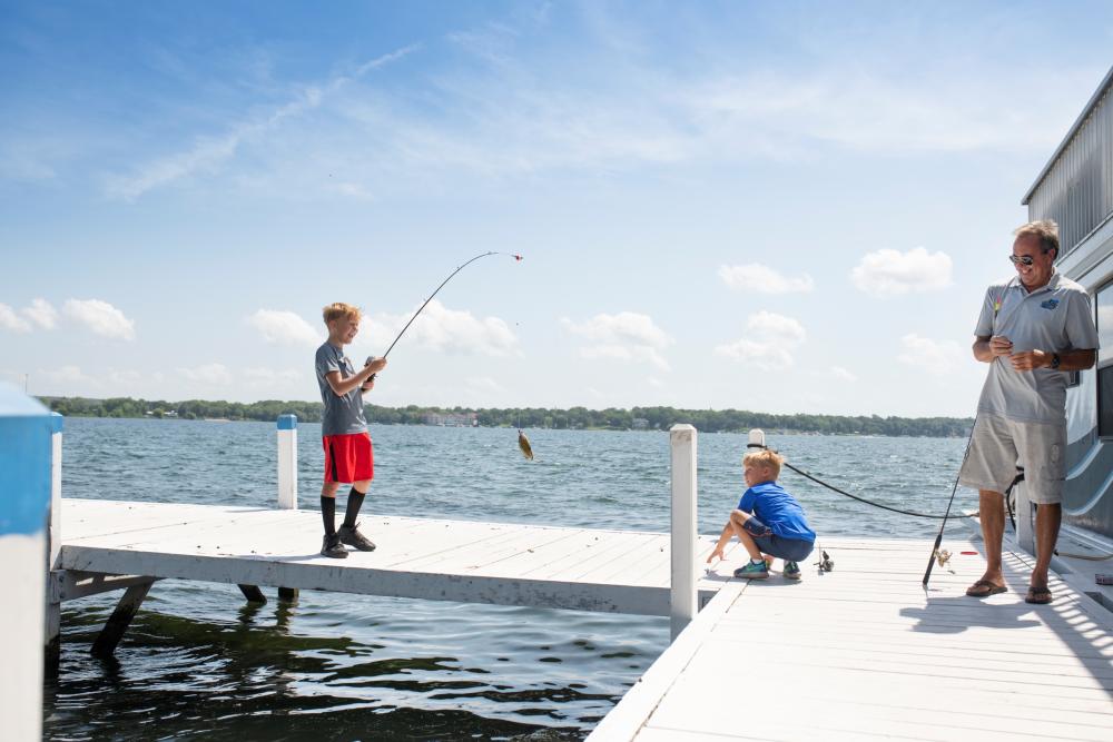 Boys and grandfather fishing on a pier