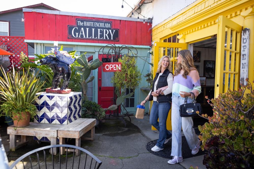 This is an image of a mother and daughter walking happily out of the entrance to the Haute Enchilada in Moss Landing