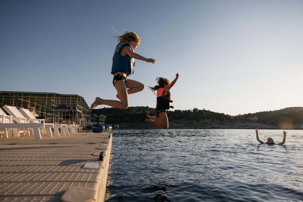 Kids jump off the dock to swim at Navajo Lake State Park, New Mexico