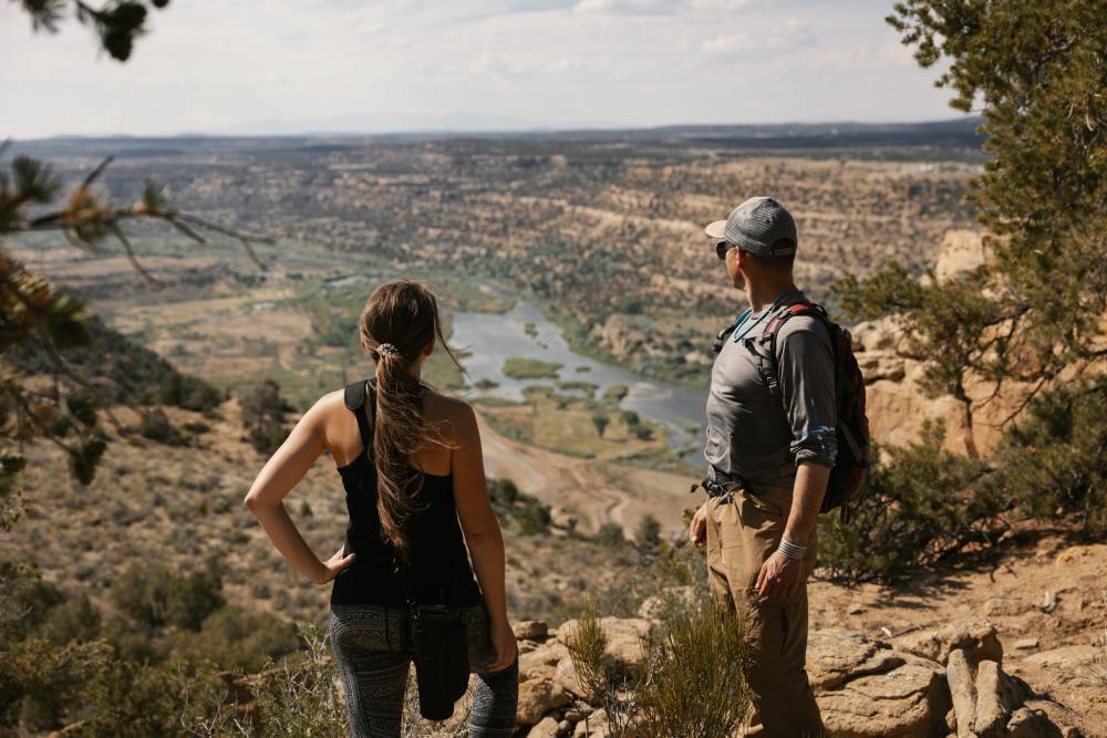 A man and woman rest while hiking a mesa over the San Juan River near Navajo Lake State Park, New Mexico.