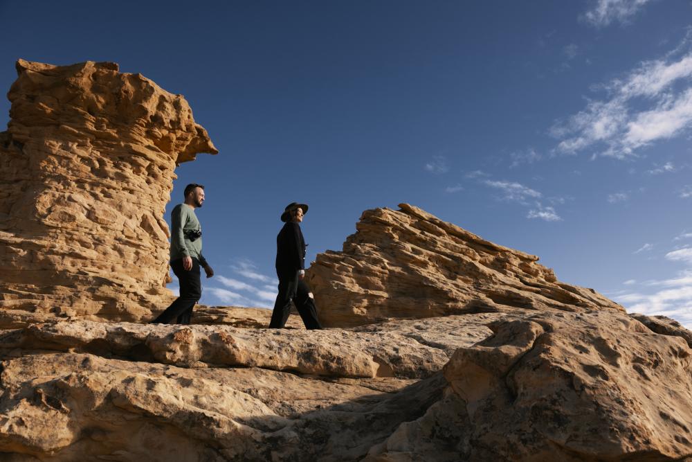 A man and woman hike along the slick rock near Grants, New Mexico.