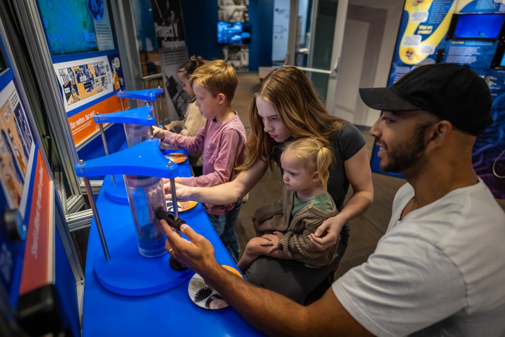 A family interacts with a scientific display at the Bradbury Museum in Los Alamos, New Mexico.
