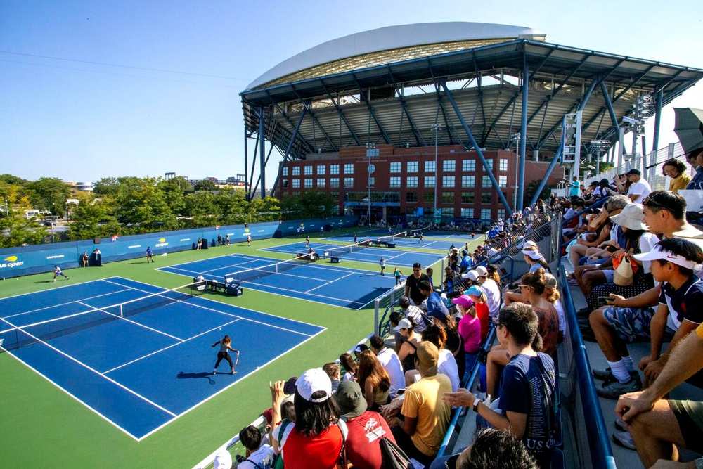Louis Armstrong Stadium during a US Open match with a full crowd and open-air roof