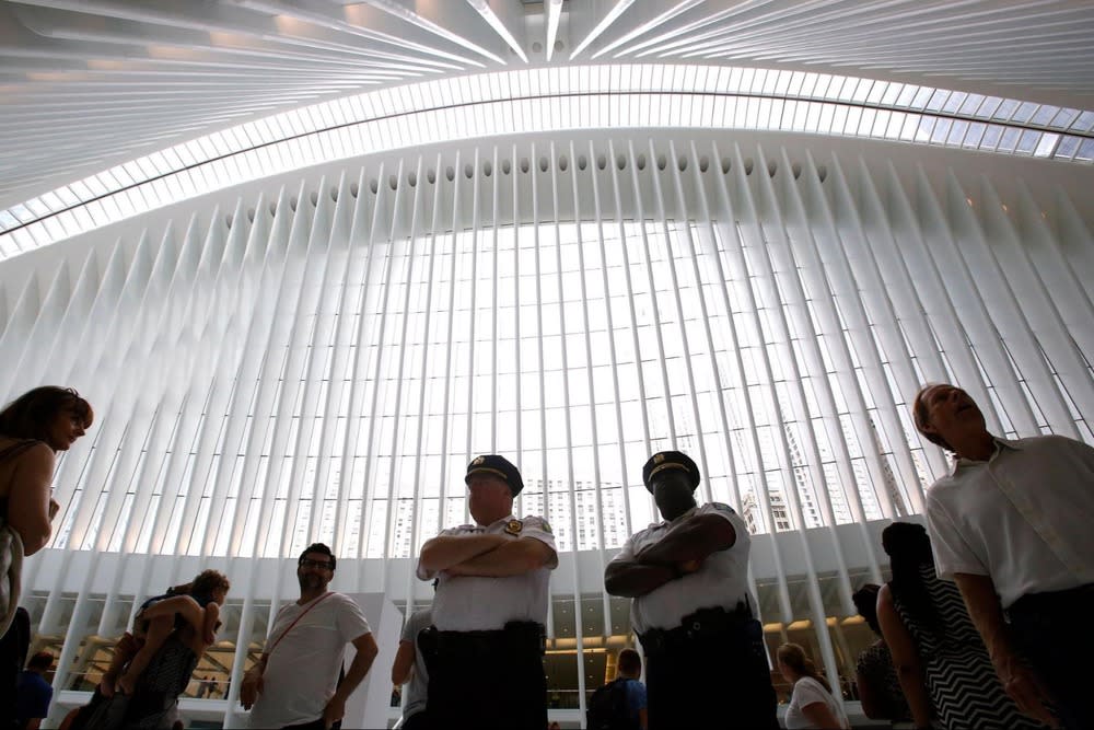 Inside a bright atrium with security staff standing beneath a tall modern ceiling.