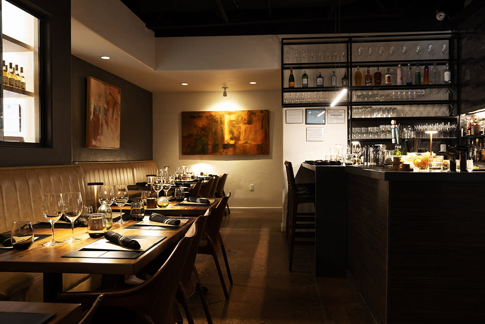 The chic dining room features dark walls, romantic lighting, and a modern-industrial bar, setting it apart from Corrales’s more rustic local businesses.